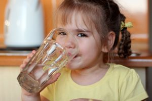  A child drinks water in a glass