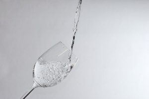 Pouring sparkling clear water in the wine glass