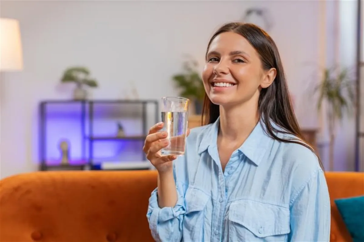 Thirsty woman hold glass of natural filtered aqua