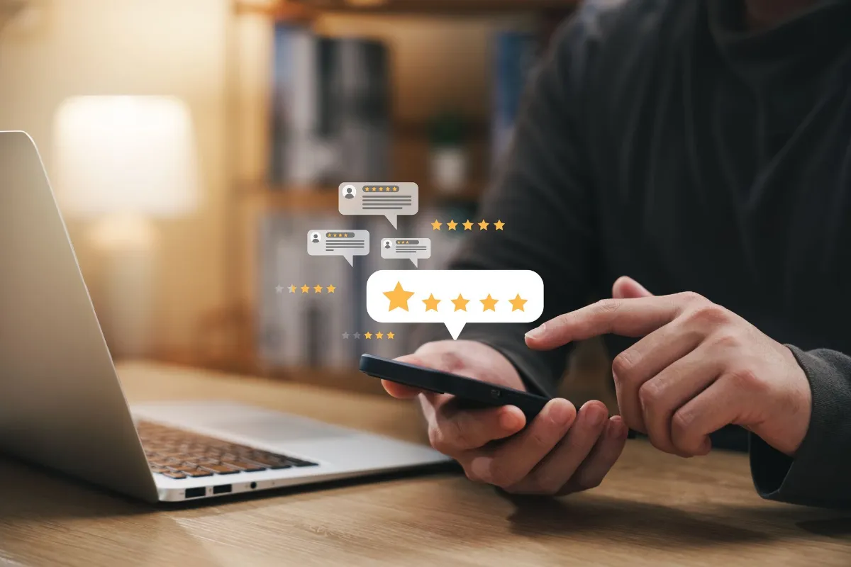 WFA-What buyers say about cheap water filters Person using a smartphone beside a laptop with floating five-star review icons representing online customer feedback and reputation management.